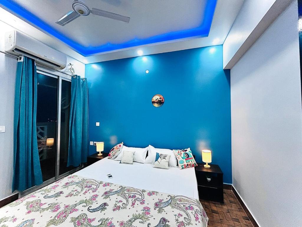 a blue room with a bed and a blue wall at SkyVista - City View Apartment 