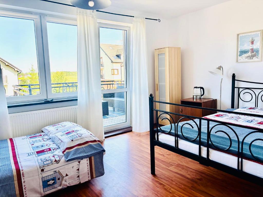 ein Schlafzimmer mit einem Bett und einem großen Fenster in der Unterkunft Julus in Łeba