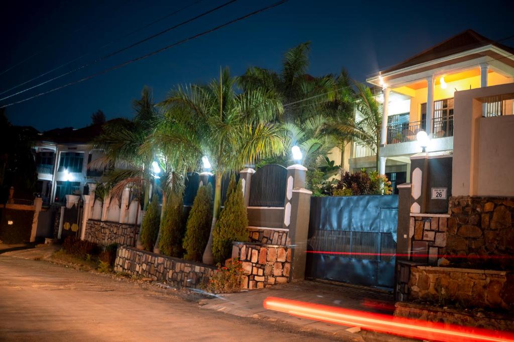 キガリにあるSGL Suites Rwandaの夜の通りにヤシの木のある家