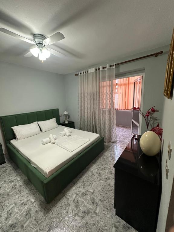 Un dormitorio con una cama verde y una ventana. en Sunny Balcony Retreat Pogradec, en Pogradec