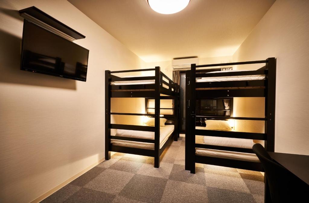 a room with two bunk beds and a flat screen tv at Rikyuan Kyoto Nishikyogoku room B in Kyoto