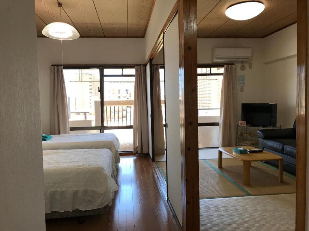 a bedroom with a bed and a living room at Weekly Harbourview Mansion Main Building / Vacation STAY 74570 in Naha