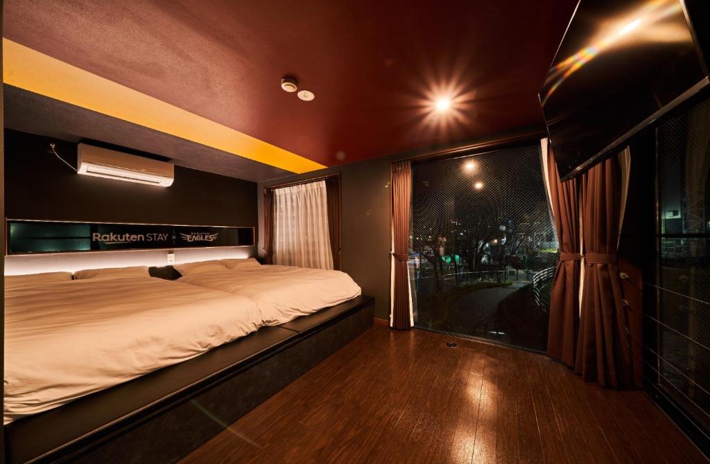 a bedroom with a bed and a large window at Rakuten STAY x EAGLES 201 with Roof balcony in Sendai