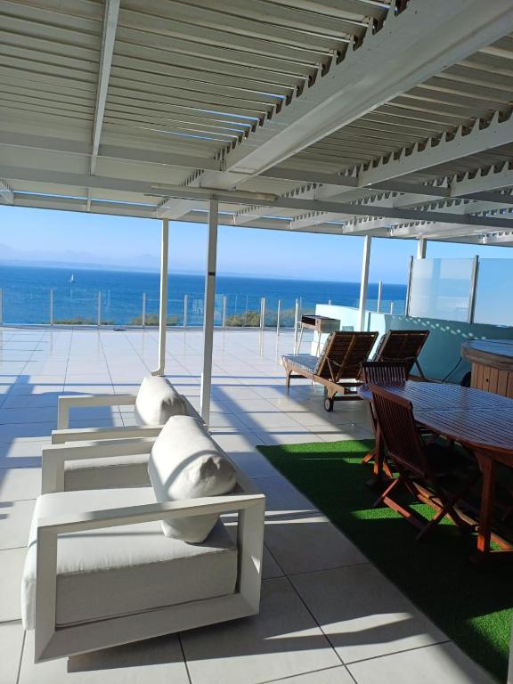 a patio with a table and chairs and the ocean at Nautica flat 401 in Mossel Bay