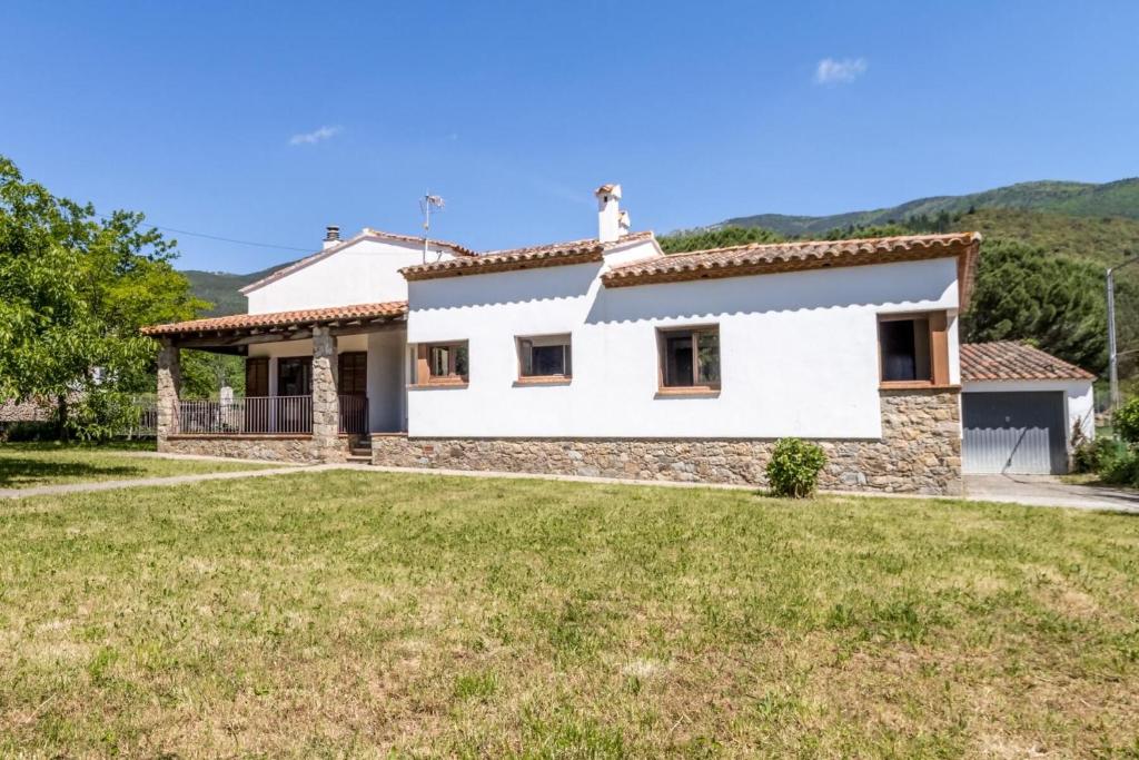 a white house with a large yard at Can Cardina - Casa con jardín cerca de Francia in Maçanet de Cabrenys