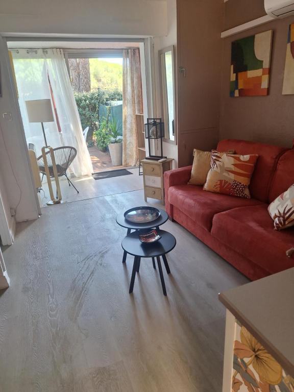 a living room with a red couch and a table at Mimilou Eleuthera 300 m centre naturiste in Cap d'Agde