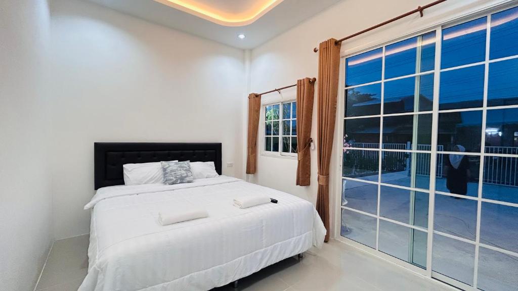 une chambre avec un lit et une grande fenêtre dans l'établissement Hatyai city habibi home 2, à Sathani Hat Yai