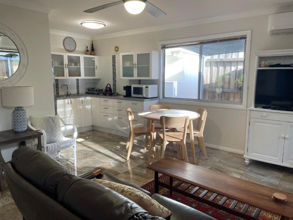 ein Wohnzimmer mit Sofa und Tisch in der Unterkunft Patonga Street Retreat in Patonga
