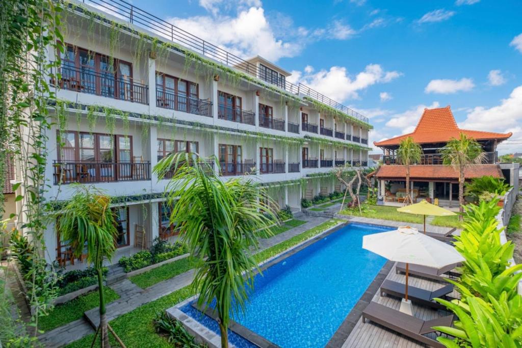 an exterior view of a hotel with a swimming pool at Puri Kaja House in Badung
