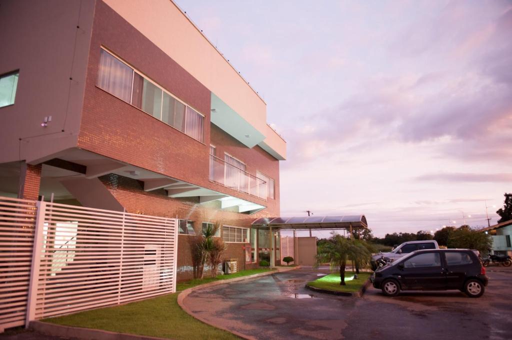 um carro estacionado num parque de estacionamento ao lado de um edifício em Italian Palace Hotel em Palmas