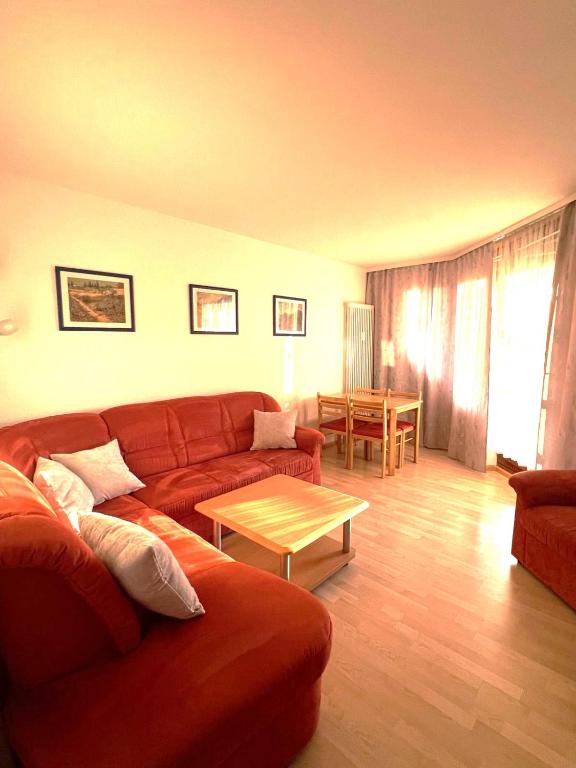 a living room with a red couch and a table at Siebert Apartment in Titisee-Neustadt