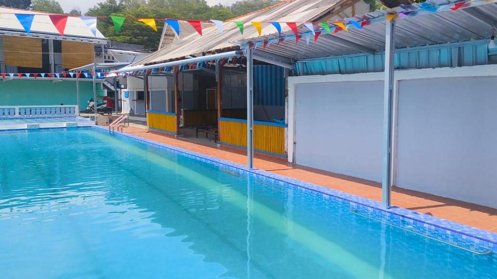a large swimming pool with flags on the side of a building at Surya Abadi Homestay Syariah RedPartner in Kebumen
