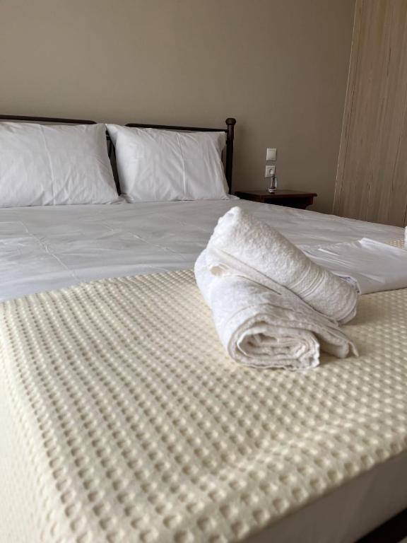 a bed with white sheets and pillows on it at Marina's house in Preveza