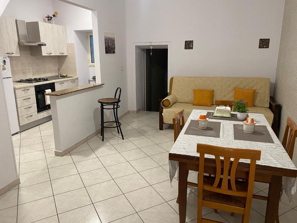 a kitchen and living room with a table and a couch at Casa Cindy in Lamezia Terme