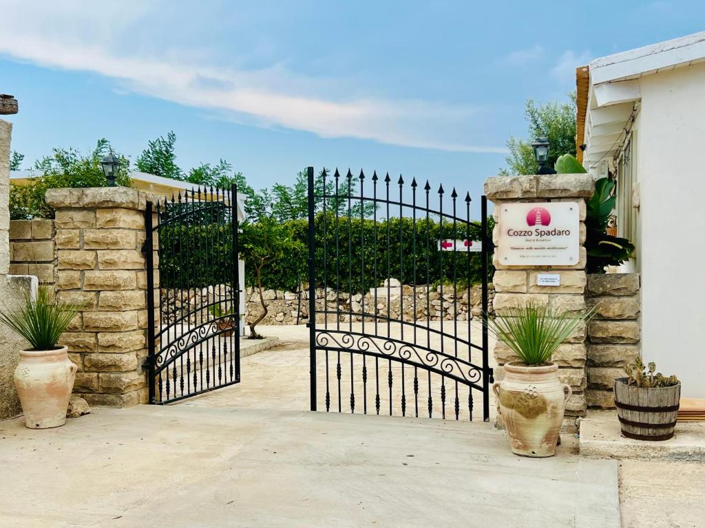 un cancello nero con un cartello davanti di Cozzo Spadaro B&B OnlyRooms a Portopalo