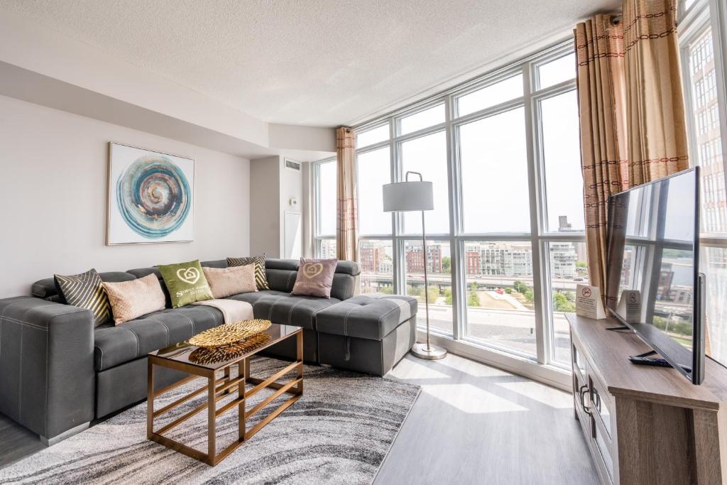 a living room with a couch and a large window at Corner 2 Bedroom 2 Bathroom Condo Balcony Iceboat Terrace Downtown Toronto in Toronto