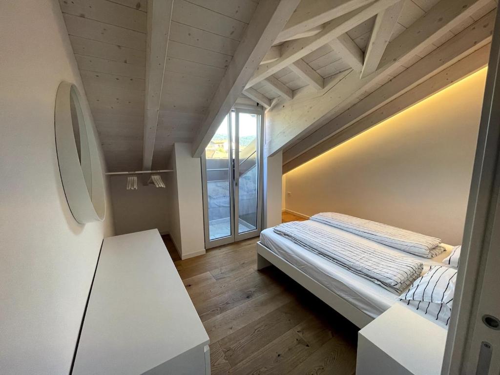 a small bedroom with a bed and a window at Attico vista Lago in Centro in Luino