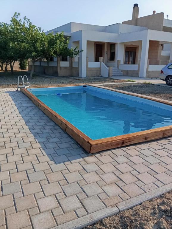 a swimming pool in front of a house at Luna's Summer House in Kremasti