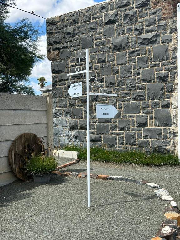 a street sign in front of a stone wall at Vyfster - Old Jail in Britstown