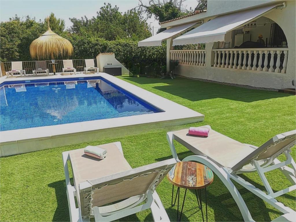 a backyard with a pool and a chair and a table at Villa Casa Segunda in Lliria