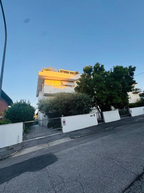 a building with a white fence next to a street at B&B Amo' in Forlì
