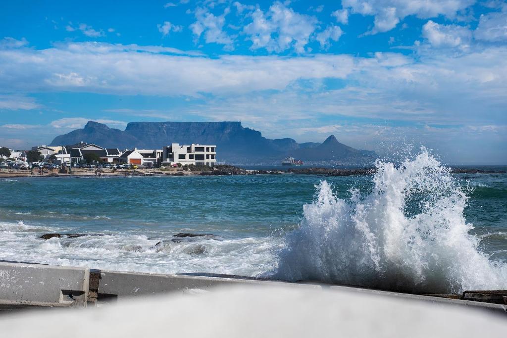 a wave in the ocean on a beach at Kleinbaai Cottage on the Sea in Cape Town