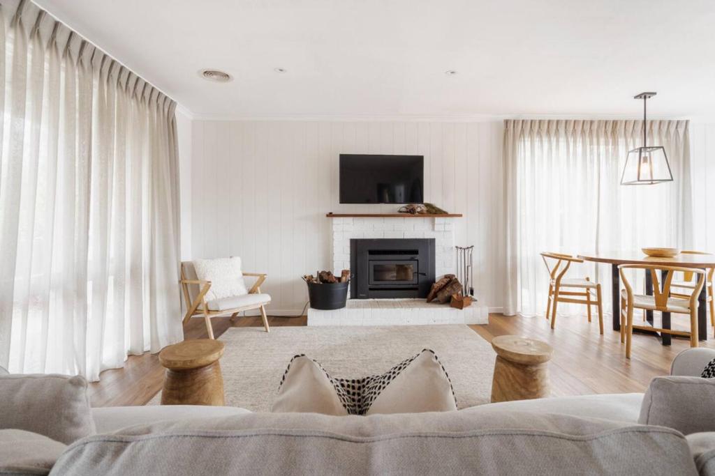 Una sala de estar con un sofá y una chimenea. en La Belle Vie - Boutique Country Escape near Wineries, en Red Hill