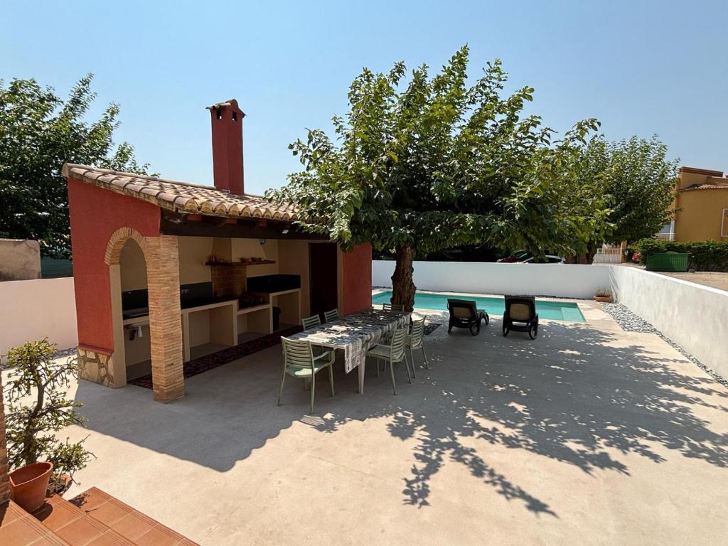 een patio met een tafel en stoelen naast een huis bij Villa Adela in Oliva