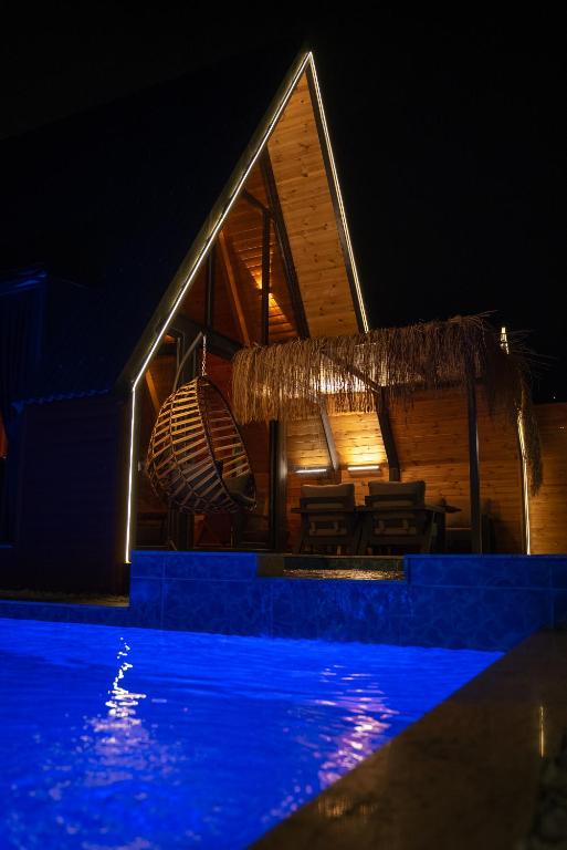 a house with a swimming pool at night at Armoni Life Bungalov in Yanık