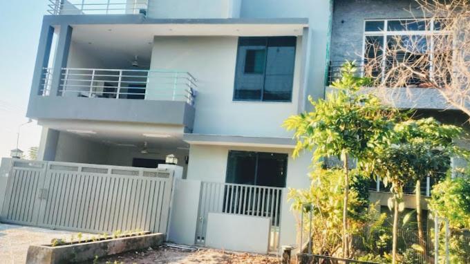 une maison avec une clôture blanche devant elle dans l'établissement Awan Guest House, à Dargai