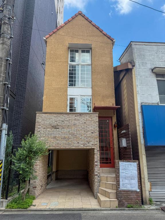 a brick building with a red door on a street at ケイアイコンホテルズプロパンズ in Nagoya
