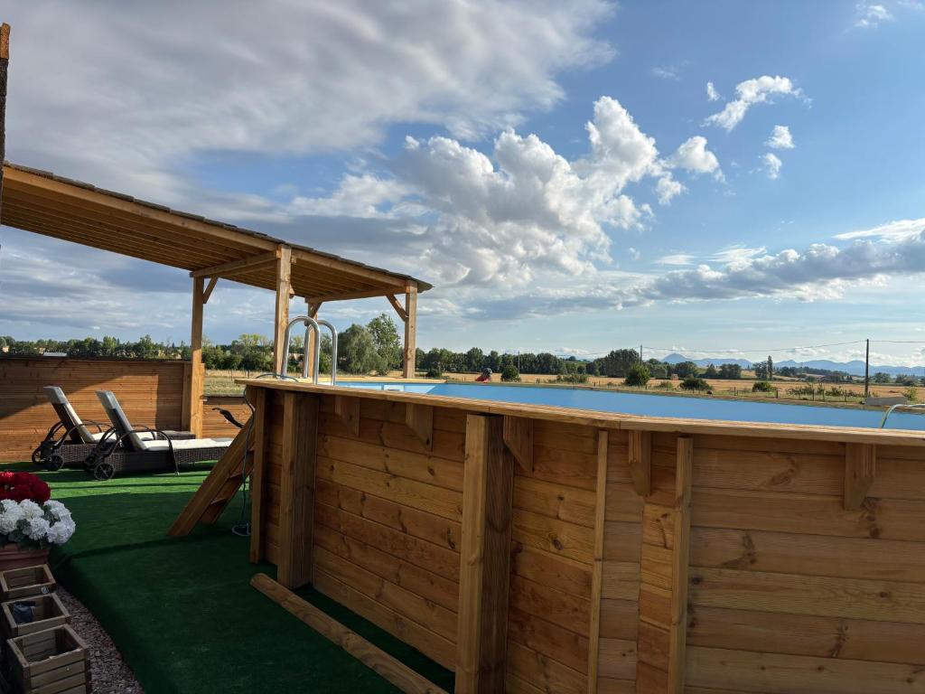 a swimming pool with a pavilion next to a swimming pool at Le petit paddock in Villeneuve-lès-Cerfs