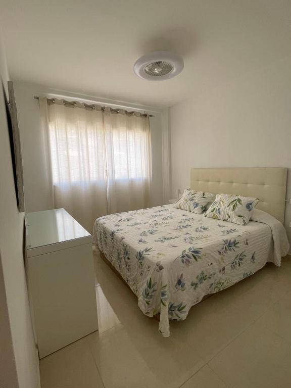 a white bedroom with a bed and a window at Cris Sol 205 in Arona