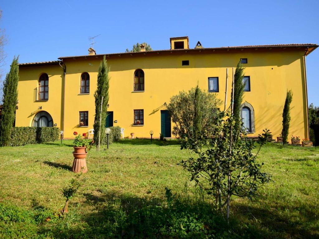 a large yellow building in a field of grass at Rustic Farmhouse Living Vinci s Treasures in Vinci