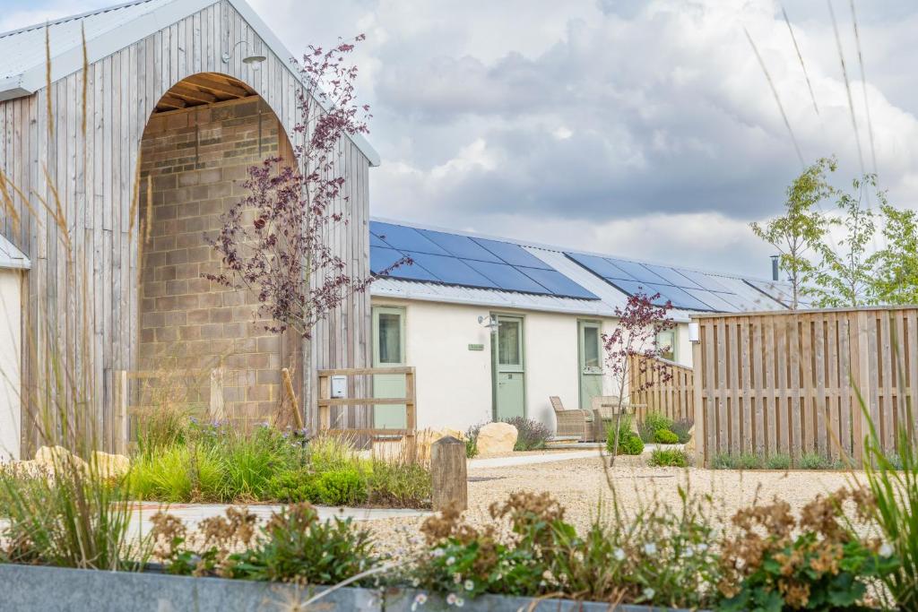 a house with solar panels on the roof at The Little Stable - Cosy 1 Bed Cottage in Burford in Swinbrook