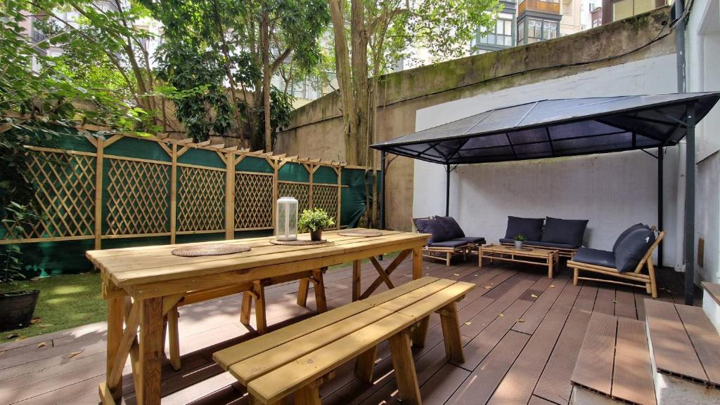 Un patio con una mesa de madera y una sombrilla. en Unique location - 130m2 & Garden close to Museums, en Bilbao