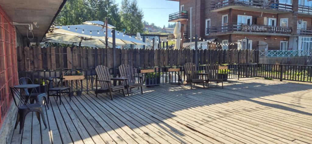 a deck with chairs and tables and a fence at Bakuriani Mgzavrebi Block 9 Apartments in Bakuriani