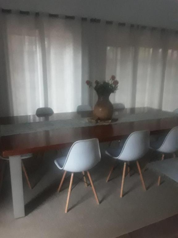 a table with chairs and a vase on top of it at Albertinia Homes in Albertinia
