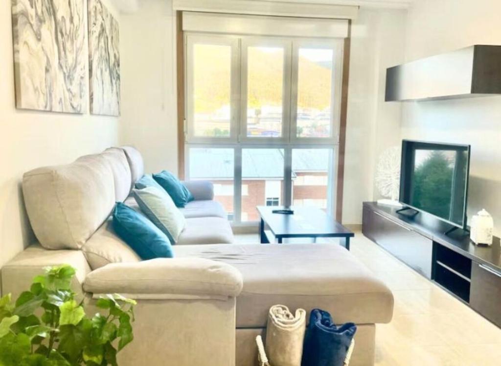 a living room with a couch and a television at Apartamento vistas al mar in Viveiro