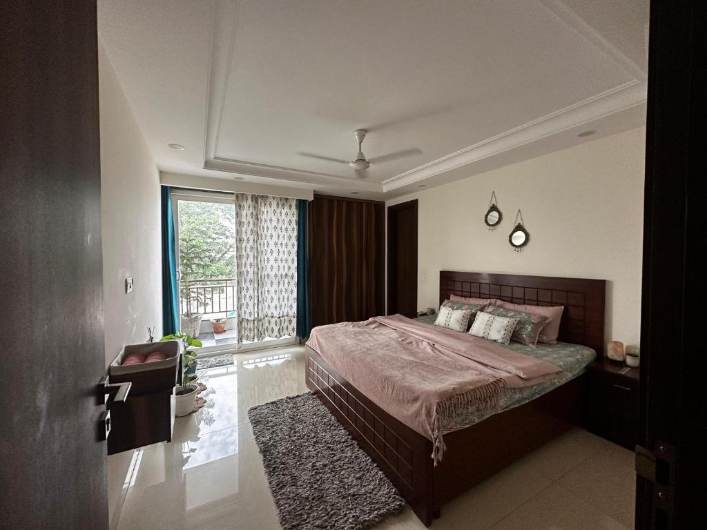 um quarto com uma cama grande e uma janela em Green & Ivory Homestay em Gurgaon