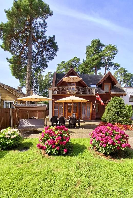 a house with some flowers in a yard at Villa Eternity in Jūrmala