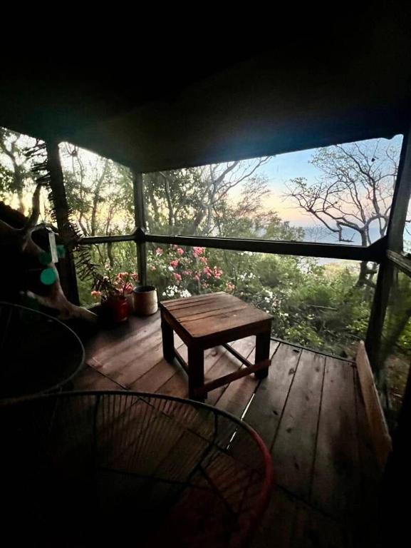 a screened in porch with a wooden table on it at Ipacebra in Yolina