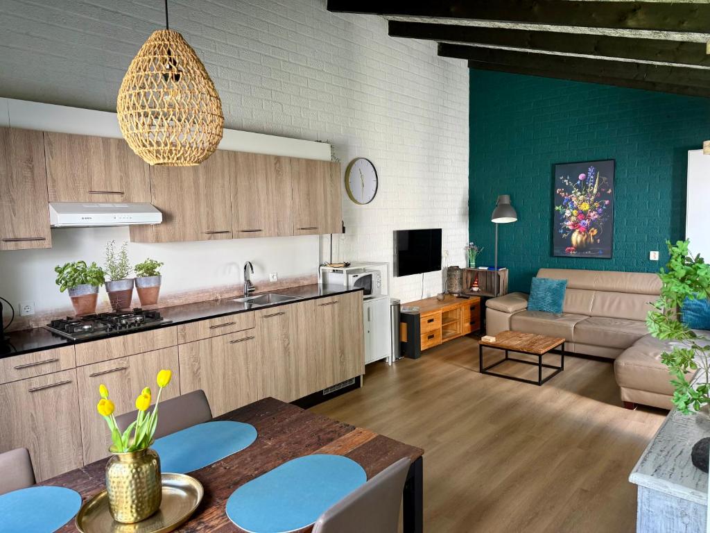 a kitchen and living room with a couch and a table at Gehele Bungalow zuid-Limburg op een park in Simpelveld