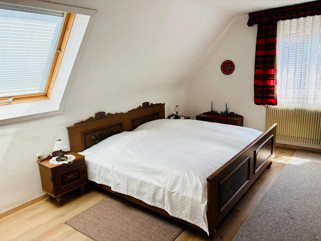 a bedroom with a large bed and a window at Ferienhaus Oesterle - Idyllisches Schwarzwaldhaus am Bach mit Terrasse & Balkon in Schönmünzach