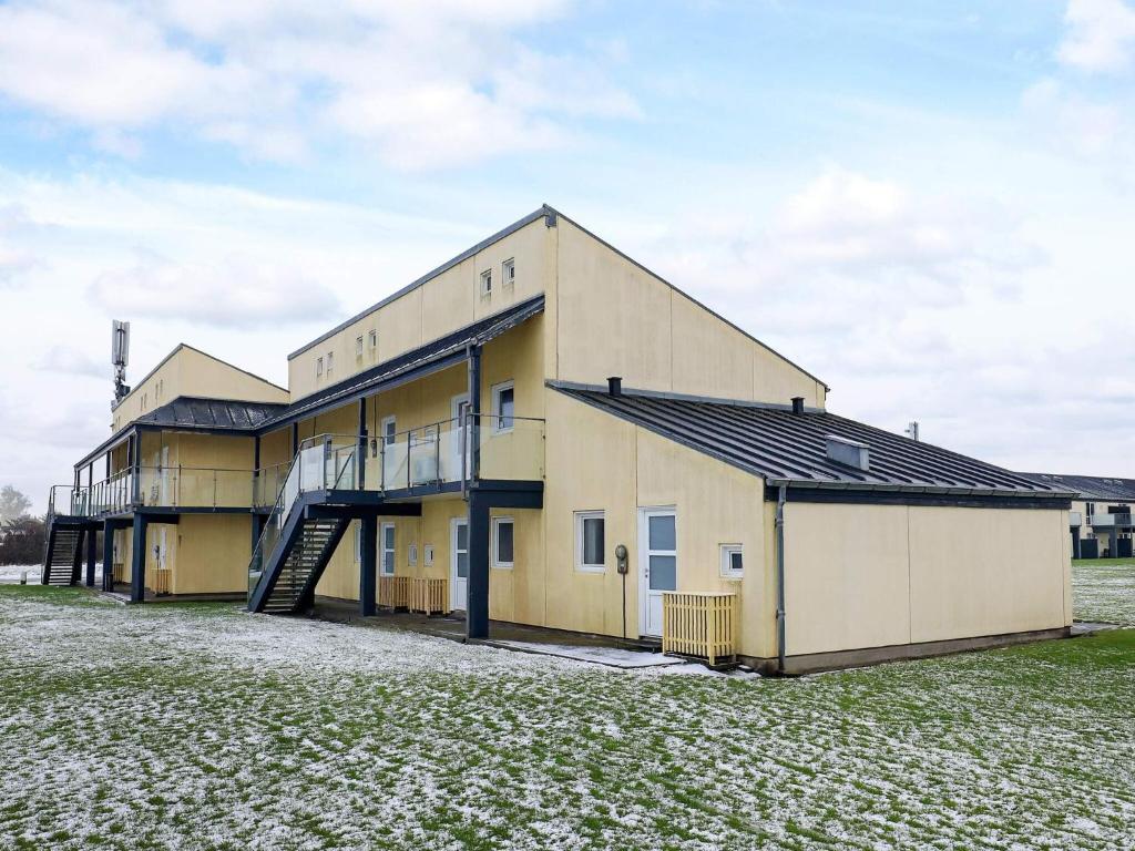 a large yellow building with a garage at 4 person holiday home in Løkken in Løkken