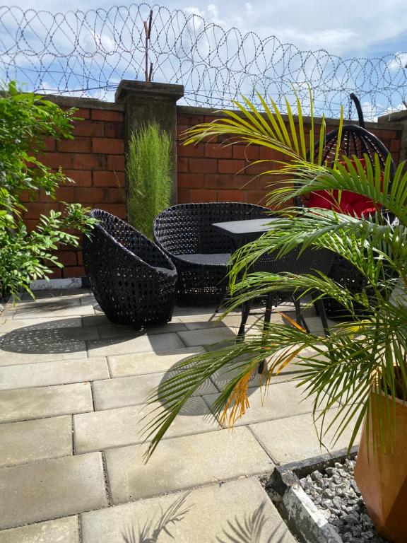 a patio with chairs and a table and a fence at Kind Maisonettes Apartments in Abuja