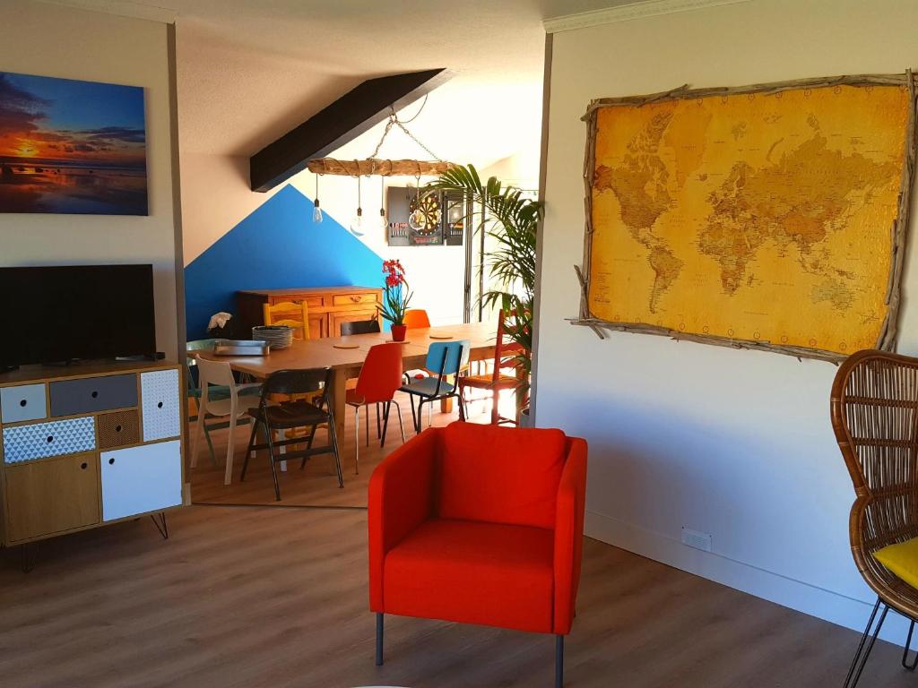 a living room with a red chair and a table at La Maison Bisca in Biscarrosse-Plage