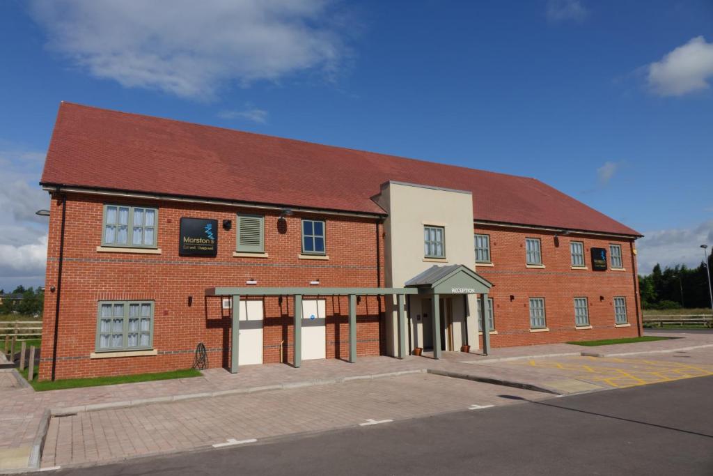 a large brick building with a red roof at Fallow Field, Telford by Marston's Inns in Telford