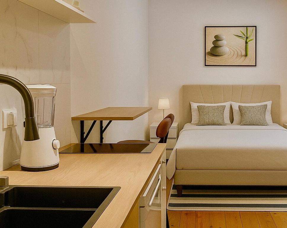 Un dormitorio con una cama y una cocina con fregadero. en Cozy and centrally located studio apartment, en Bruselas