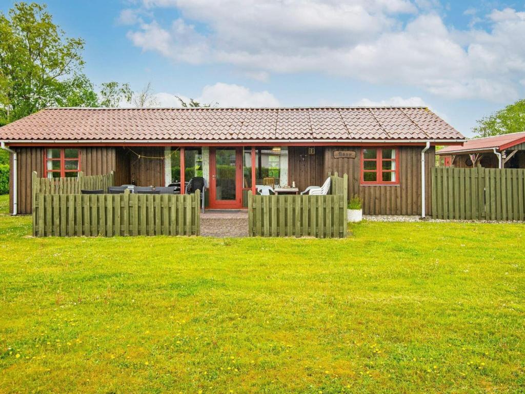 una pequeña casa con una valla en un patio en 5 person holiday home in Tarm, en Tarm